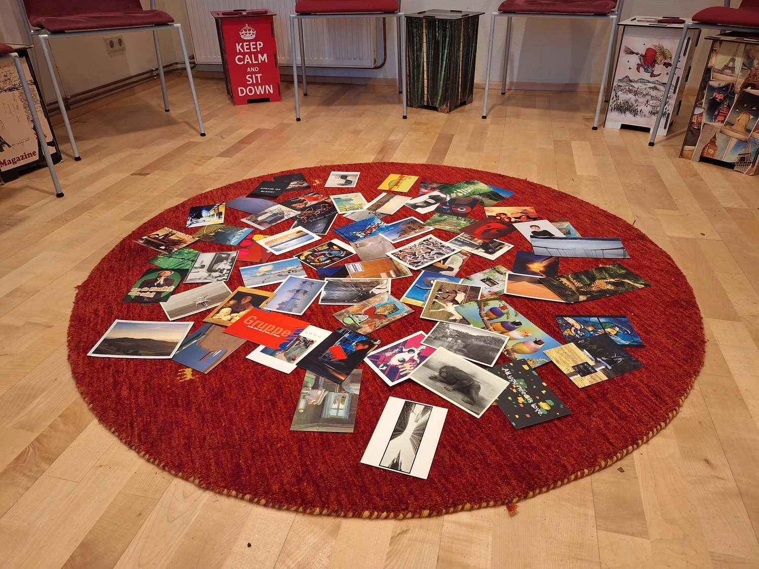 Beratung, Coaching, Supervision, Training, Moderation – Ein runder roter Teppich, bedeckt mit großen verstreuten Fotodrucken