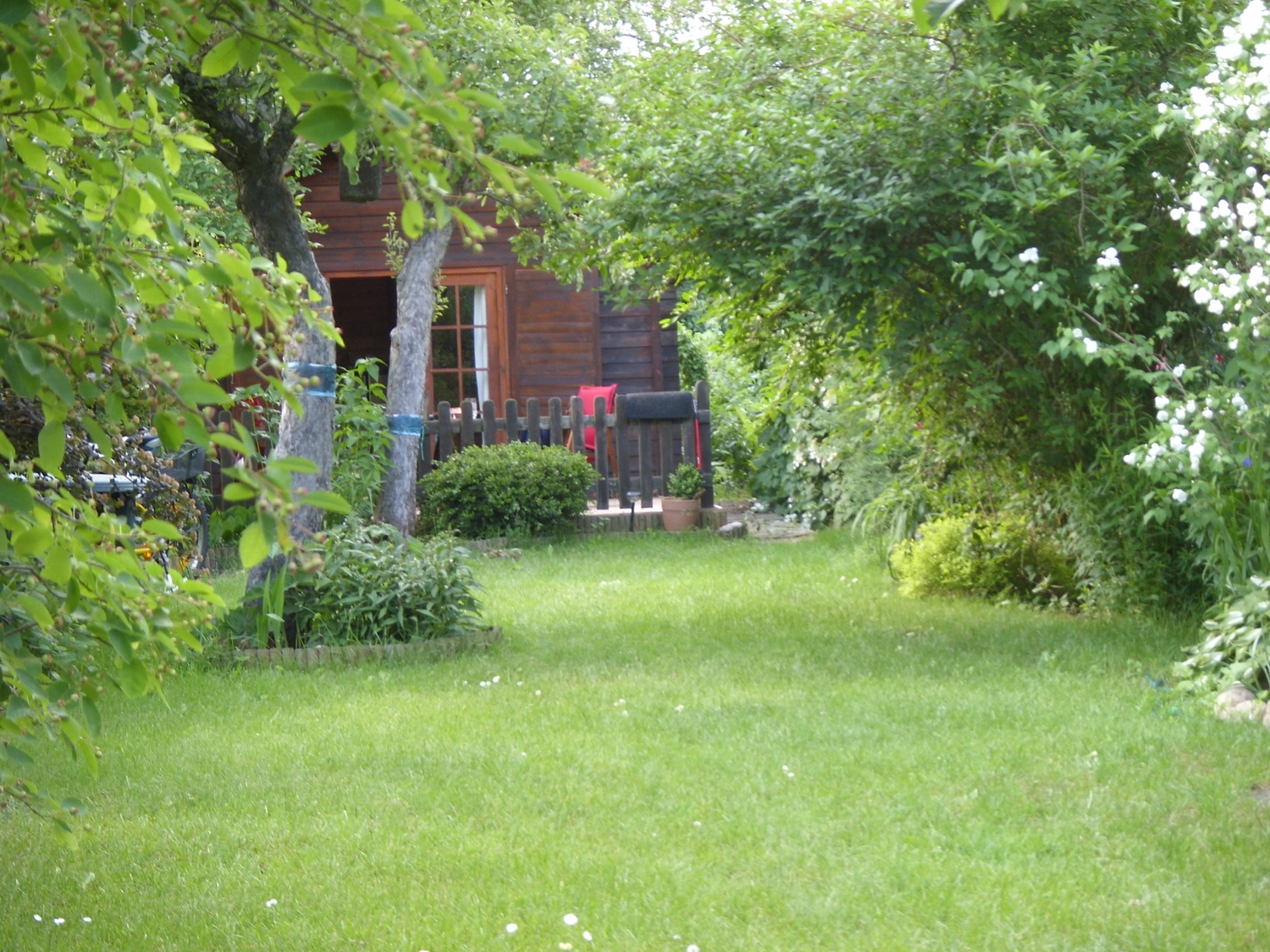 Beratung, Coaching, Supervision, Training, Moderation – Holzhütte mit Fenster und schwarzem Lattenzaun, der zu einer Veranda führt